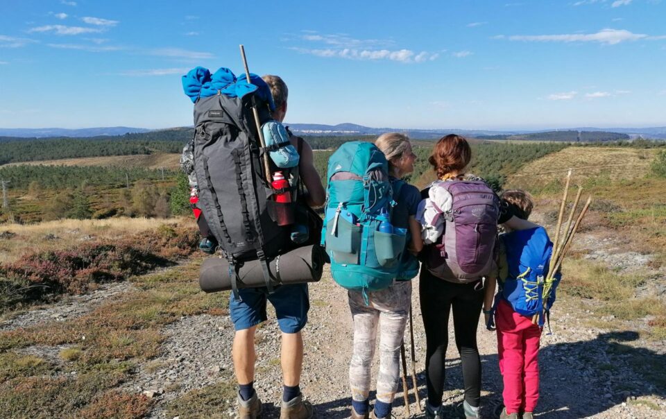 Nirmala, her husband, and two children with backpacks walking side by side on the pilgrimage route to Santiago de Compostela.