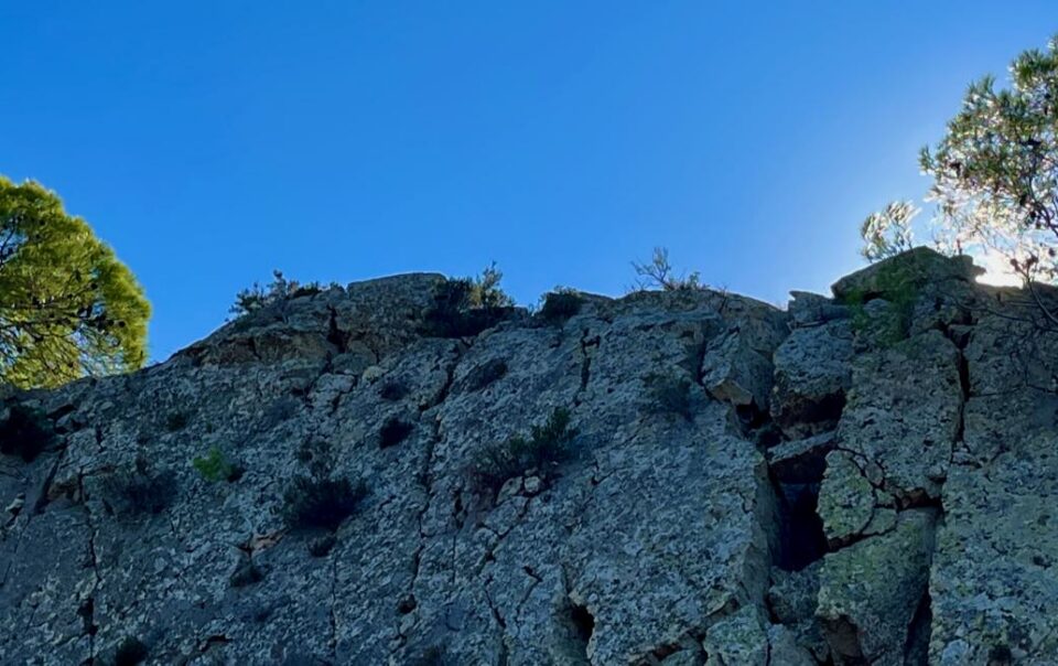 Felsen mit Bäumen vor blauem Himmel